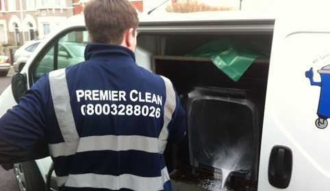Staff cleaning residential bin